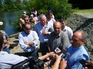 Junto al agua, rodeado de prensa y con mensaje de cuidado. 