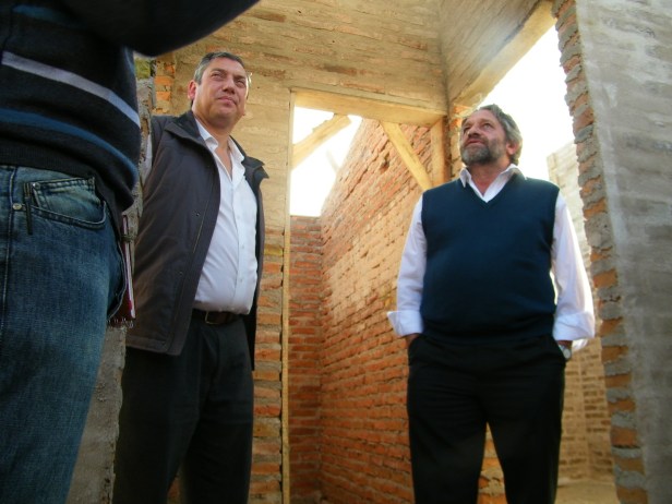 Beltrame, junto al intendente Enciso, en una vivienda del asentamiento.