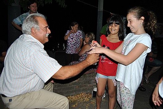 Giachetto abriendo una botella de agua a una niña que se lo pidió en la Plaza Carlos Gardel.